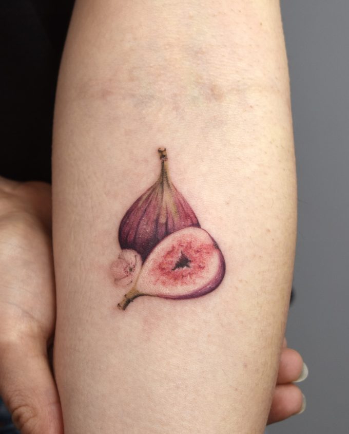 Tatouage d'une figue entière et d'une figue ouverte sur un avant-bras